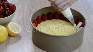 厨师挤压奶油。 手捏鲜奶油糕点袋.. 做草莓蛋糕